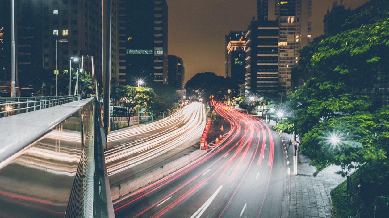 Free Time-lapse Photography of Passing Vehicles on City Roads at Night Stock Photo