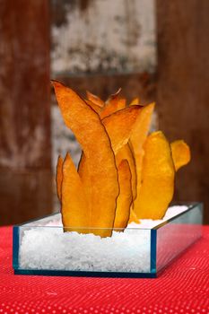 Dried mango slices artistically arranged in salt, creating a vibrant and stylish display.