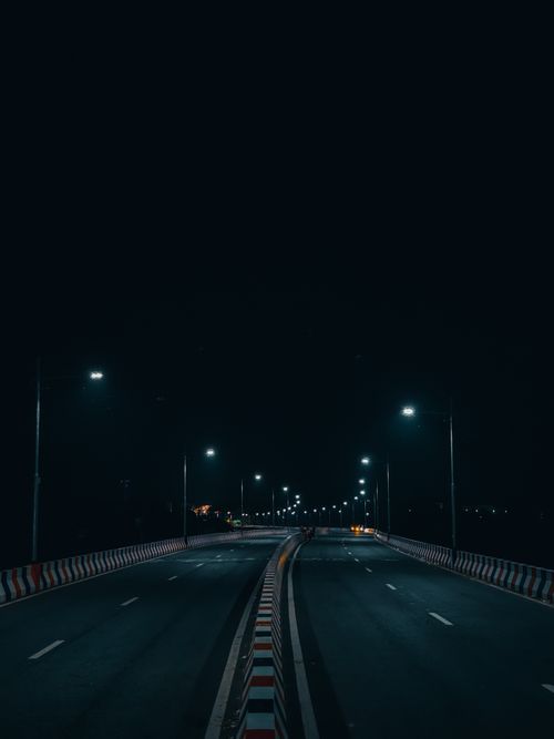 Free A serene view of an illuminated highway in Rajshahi, Bangladesh at night with streetlights. Stock Photo