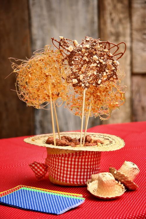 Free Colorful chocolate and sugar lollipops styled creatively in a straw hat, perfect for a festive dessert display. Stock Photo