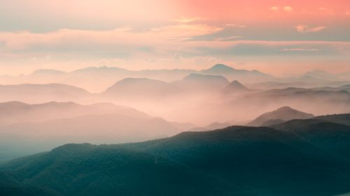 Free Serene view of misty mountains at dawn with warm colors and a tranquil atmosphere. Stock Photo