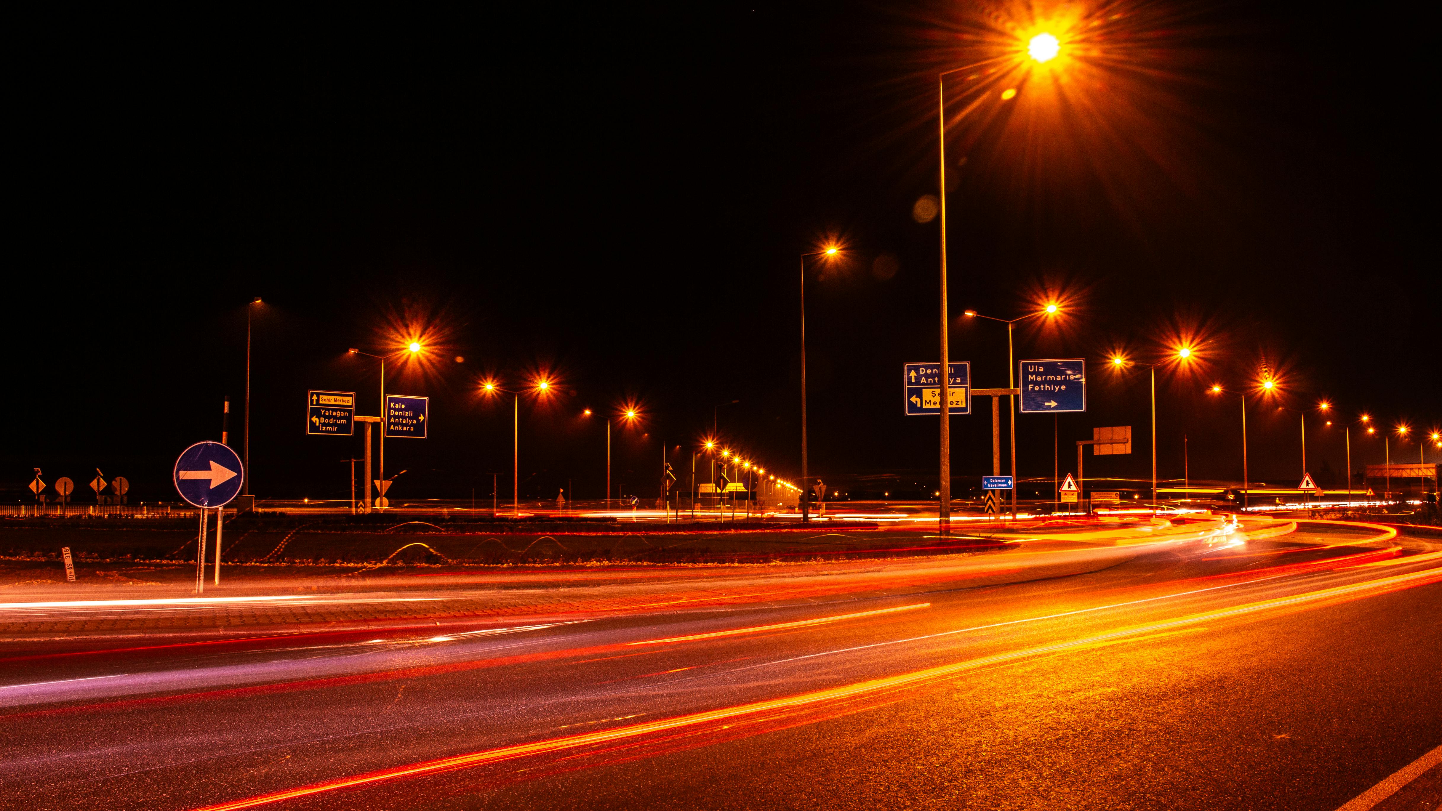 Long exposure of car lights on an urban street at night, showcasing dynamic traffic flow.