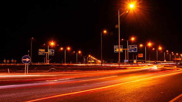 Long exposure of car lights on an urban street at night, showcasing dynamic traffic flow.