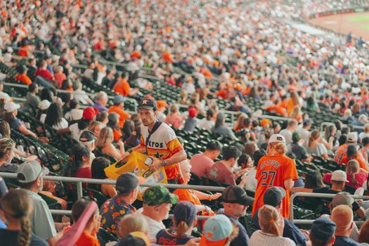 A fan checking their phone for Astros ticket deals outside the stadium.