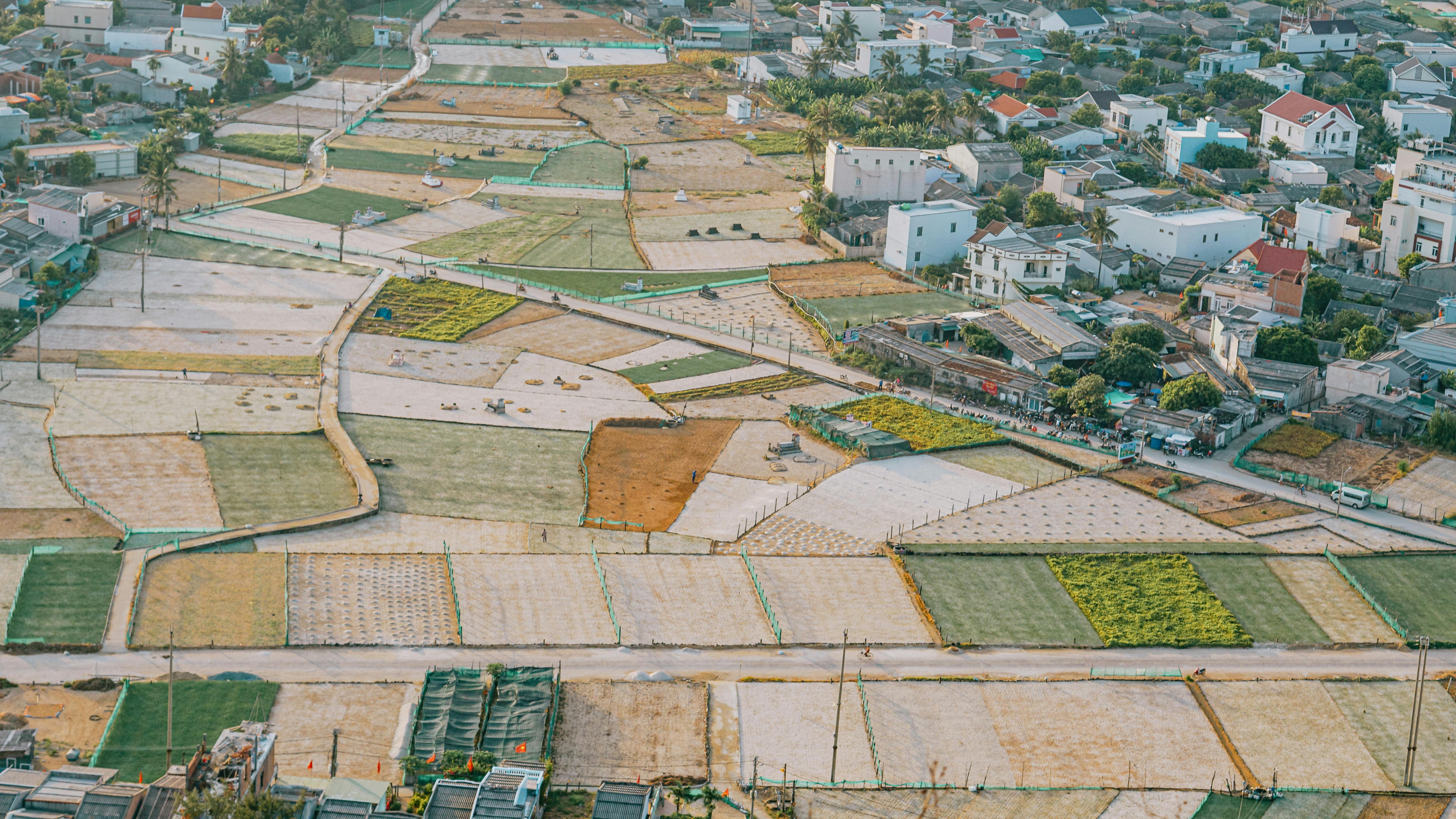 Aerial view of fields and residential area in rural Quảng Ngãi, Vietnam under daylight.