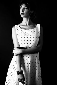 Chic black and white portrait of a model in a polka dot dress, exuding elegance.