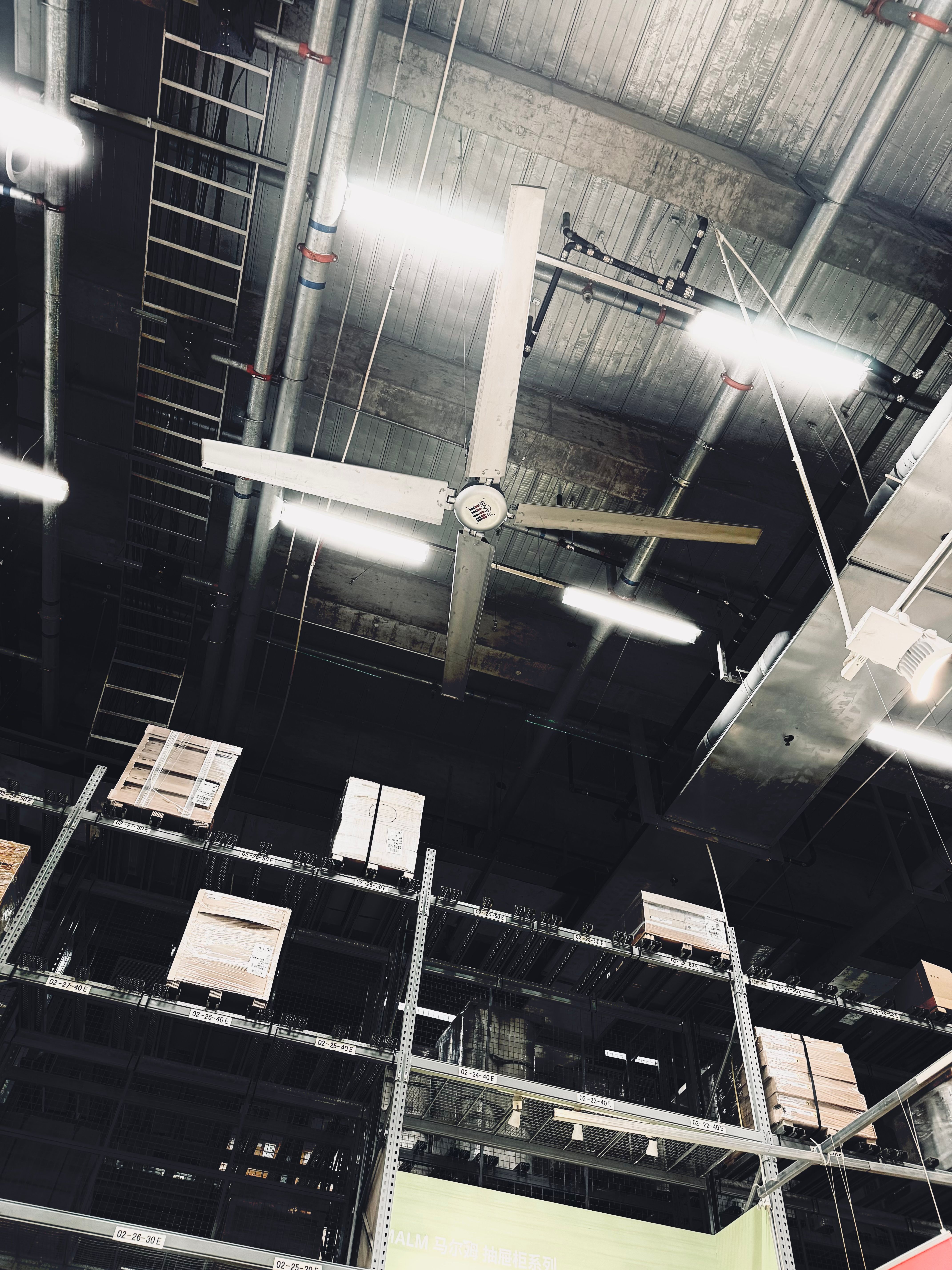Large ceiling fans running high in an open commercial building