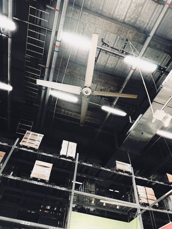 Large ceiling fans running high in an open commercial building