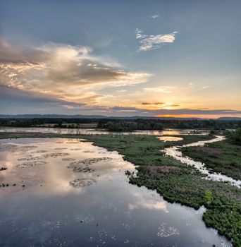 Aerial view of a vibrant sunset reflecting over Weaver, Minnesota wetlands.