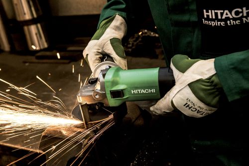 Free Close-up of a worker using an angle grinder in a workshop, producing bright sparks. Stock Photo