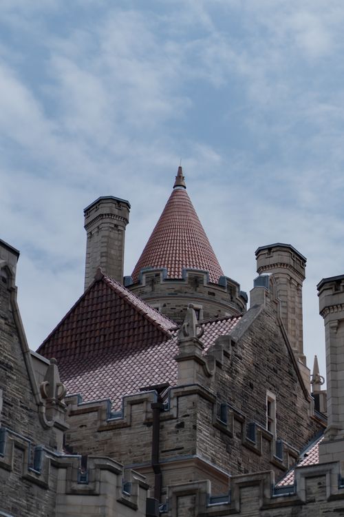 Free A picturesque view of castle towers with red roofs under a partly cloudy sky. Stock Photo