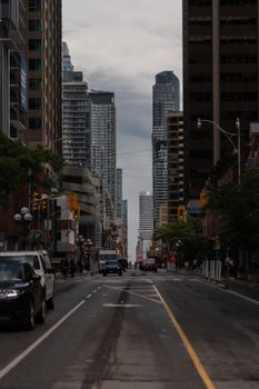 A vibrant city street scene showcasing the towering skyscrapers and bustling urban life of a downtown district.