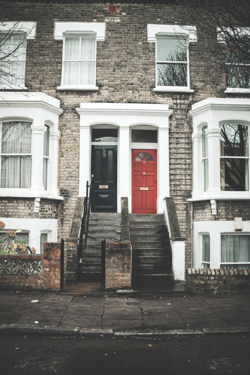 Free Elegant urban row houses with red and black doors, showcasing classic architectural style. Stock Photo