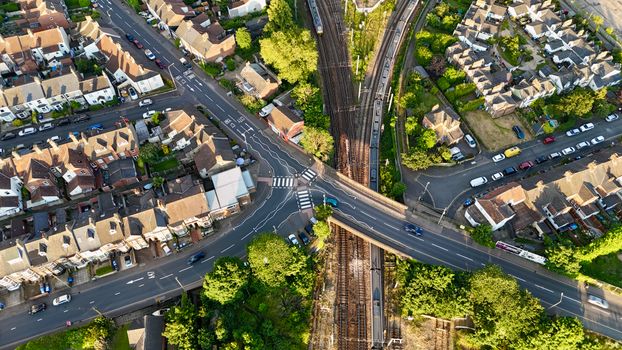 Aerial view of a residential intersection and railway in Norfolk, England, showcasing urban planning.