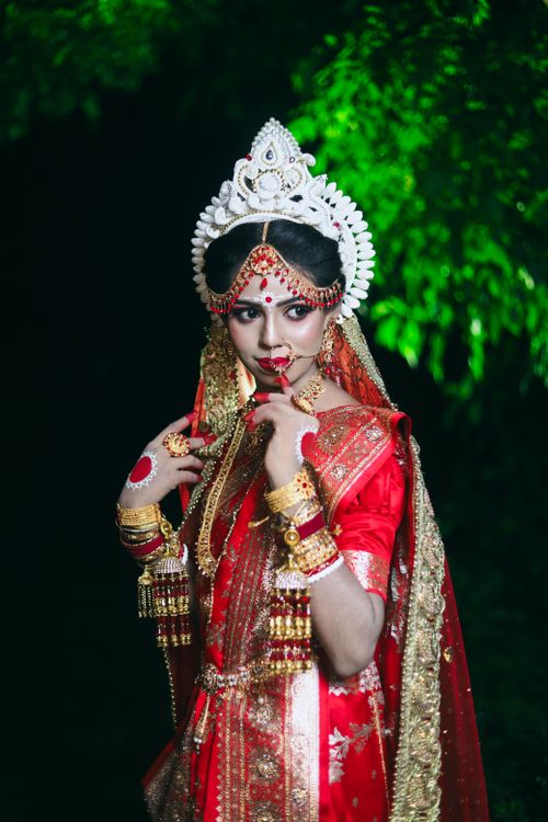 Free A stunning South Asian bride in vibrant traditional attire poses gracefully outdoors. Stock Photo
