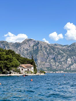Stunning summer view of Perast, Montenegro with rugged mountains and clear blue sea.