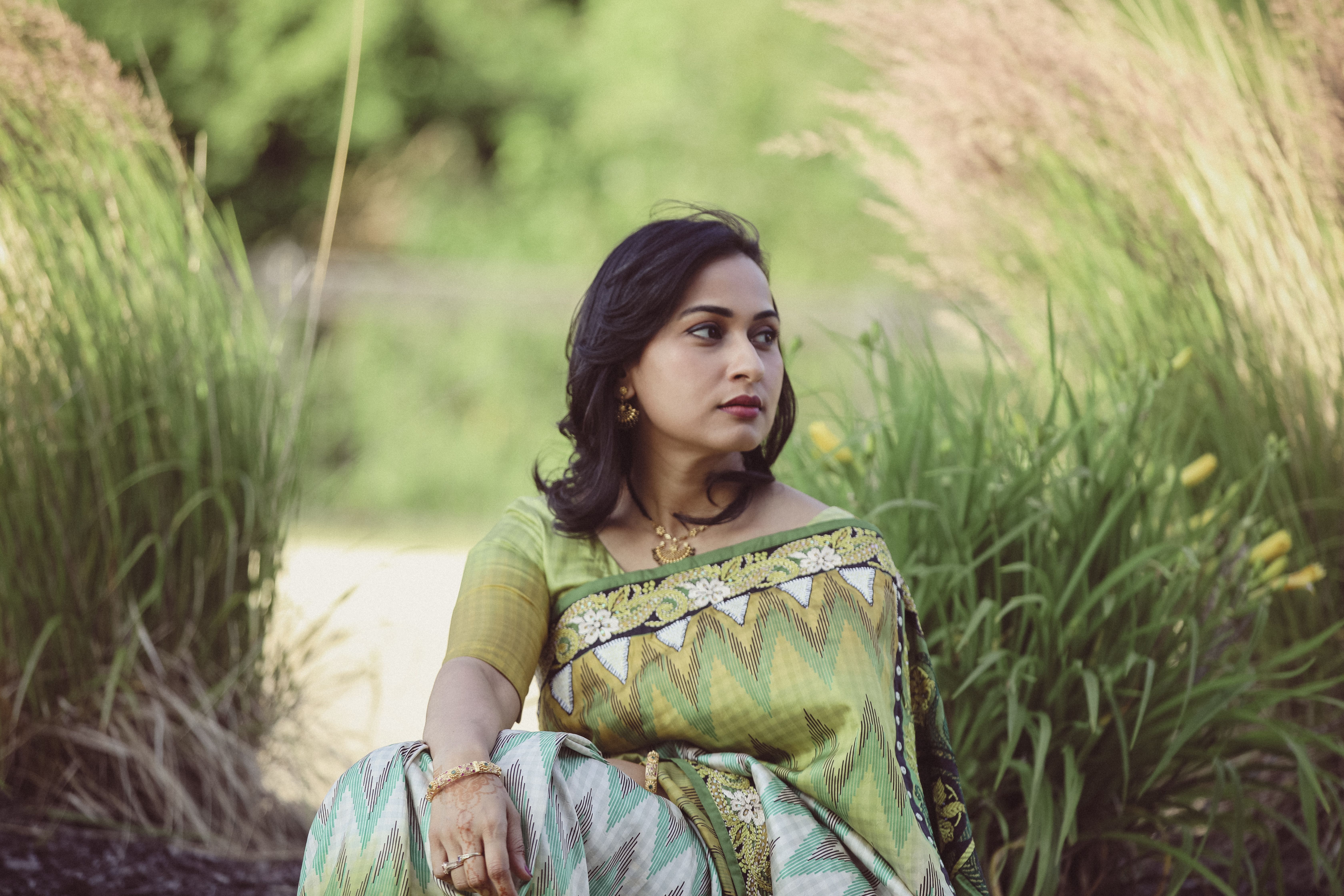 Portrait of a Pretty Brunette Sitting between Reeds · Free Stock Photo