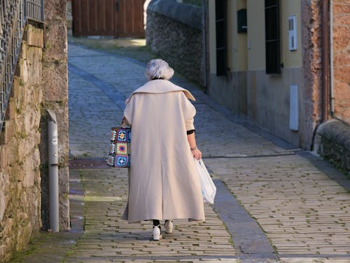 A woman walking down a cobblestone street