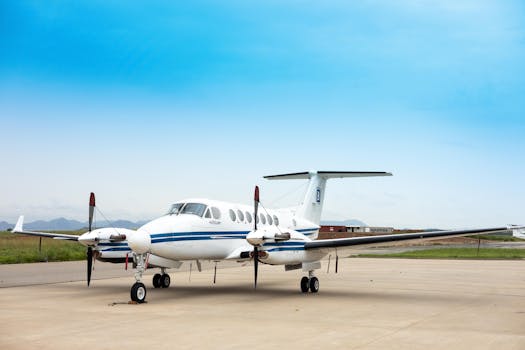 A private airplane sits on an airstrip under a clear blue sky, ready for departure.