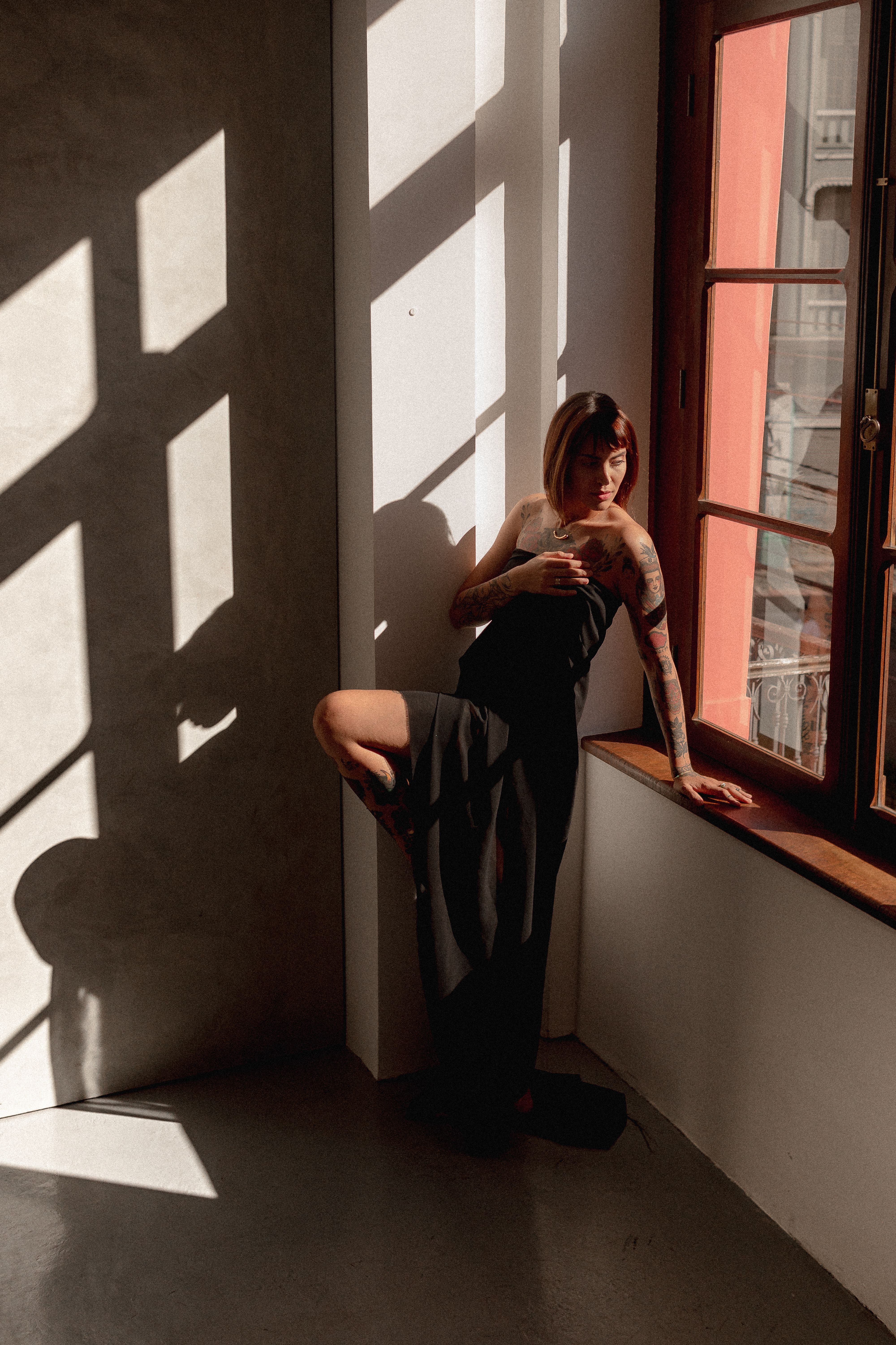 Tattooed Model in Black Dress Posing by Window · Free Stock Photo