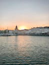 日落时分，充满活力的城市海滨上，船只和历史建筑映入眼帘