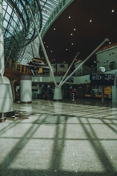 Interior view of Kuala Lumpur airport showcasing modern architectural design with sunlight reflections.