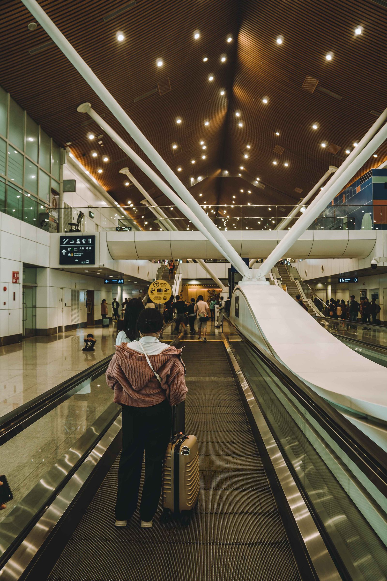 Traveller descending an escalator inside an airport terminal