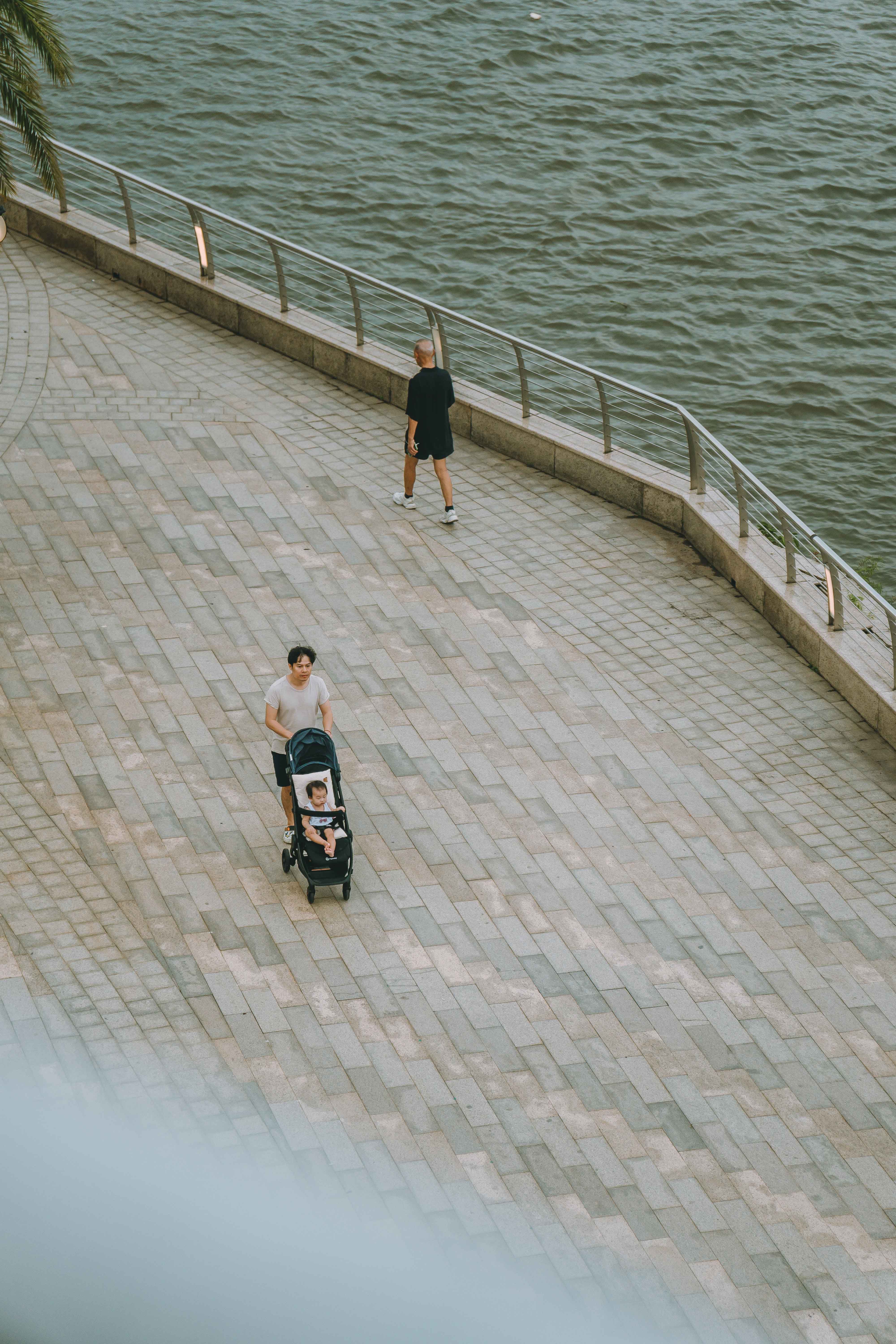 A serene scene of people enjoying a walk along the riverfront in Ho Chi Minh City, Vietnam.