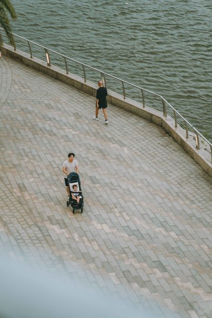 A serene scene of people enjoying a walk along the riverfront in Ho Chi Minh City, Vietnam.