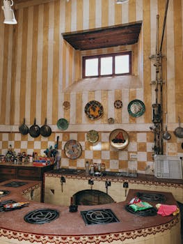 A charming rustic kitchen featuring decorative wall plates, cookware, and a cozy design aesthetic.