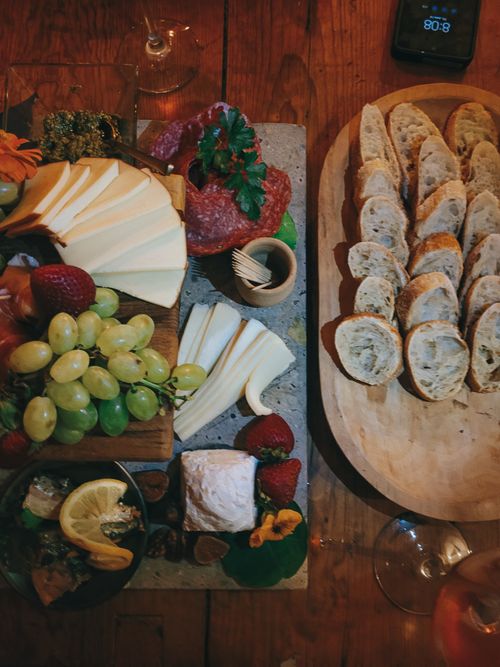 Free Top view of a delicious cheese and bread platter with grapes and meats, perfect for gourmet dining. Stock Photo