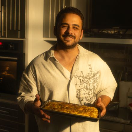 Baker holding a fresh tray from his kitchen, photo by khezez on Pexels