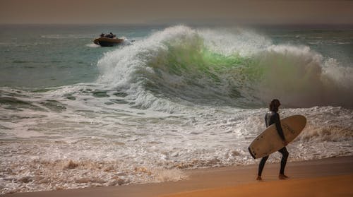Mann, Der Surfbrett An Der Küste Trägt