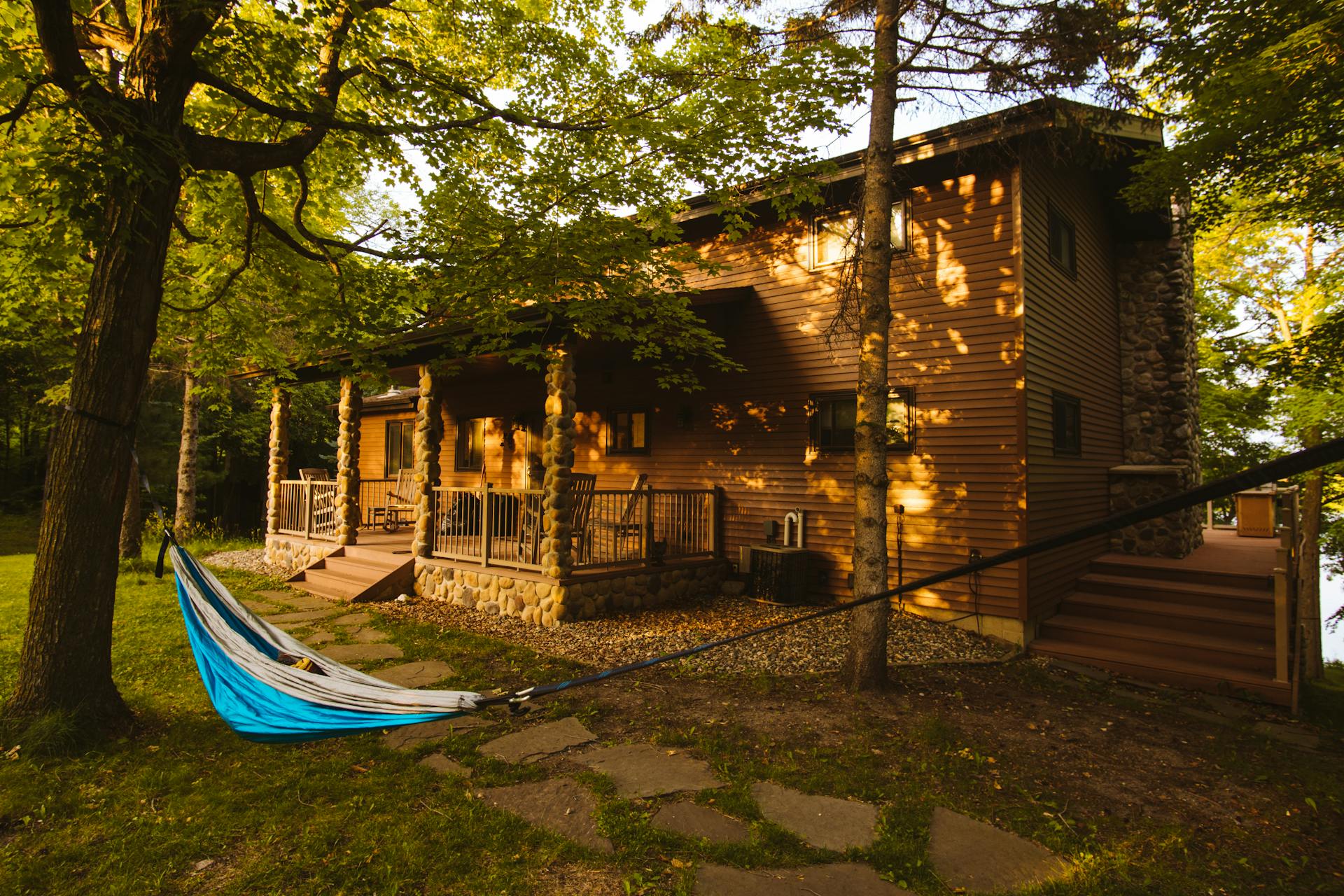 Cozy log cabin nestled among trees in Pelican Rapids, Minnesota at sunset.