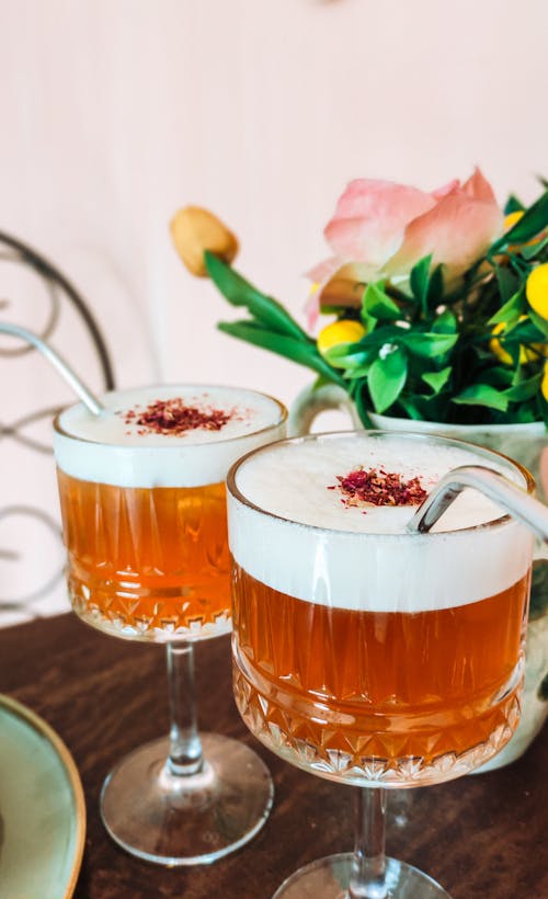 Two glasses of drink with pink liquid and flowers