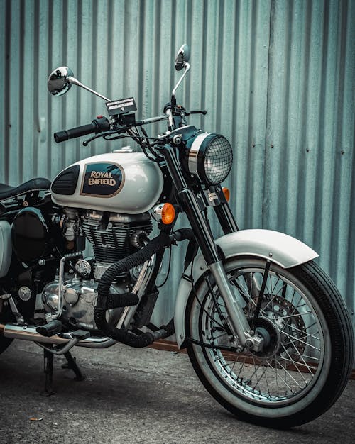 Free A classic Royal Enfield motorcycle parked against a corrugated metal wall in Los Baños, Philippines. Stock Photo