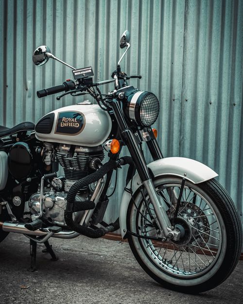 Free A classic Royal Enfield motorcycle parked against a corrugated metal wall in Los Baños, Philippines. Stock Photo