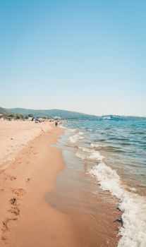 Tranquil beach with gentle waves and a clear sky, perfect for a summer day.