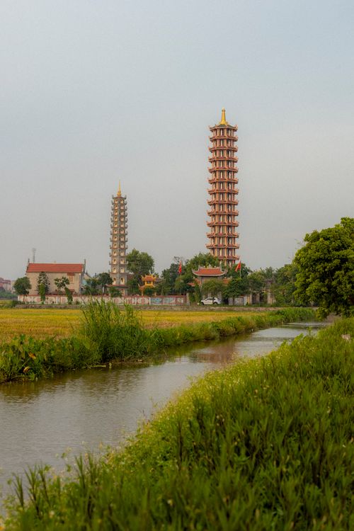 Free Peaceful scenery featuring pagodas and canal in lush countryside. Stock Photo