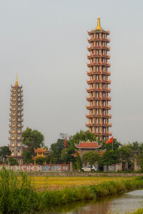 Free Captivating view of traditional Vietnamese pagodas amidst fields and river, offering cultural beauty. Stock Photo