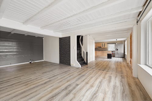 An empty room with wooden floors and a white ceiling