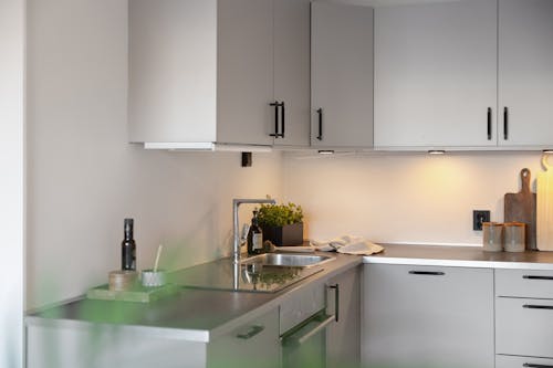 A modern kitchen with white cabinets and a sink