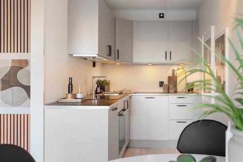 A white kitchen with a black table and chairs