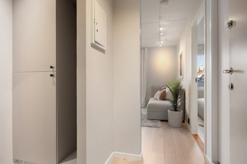 A hallway with a white door and a white couch