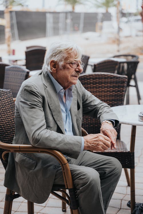 Free An older man sitting at a table in a restaurant Stock Photo
