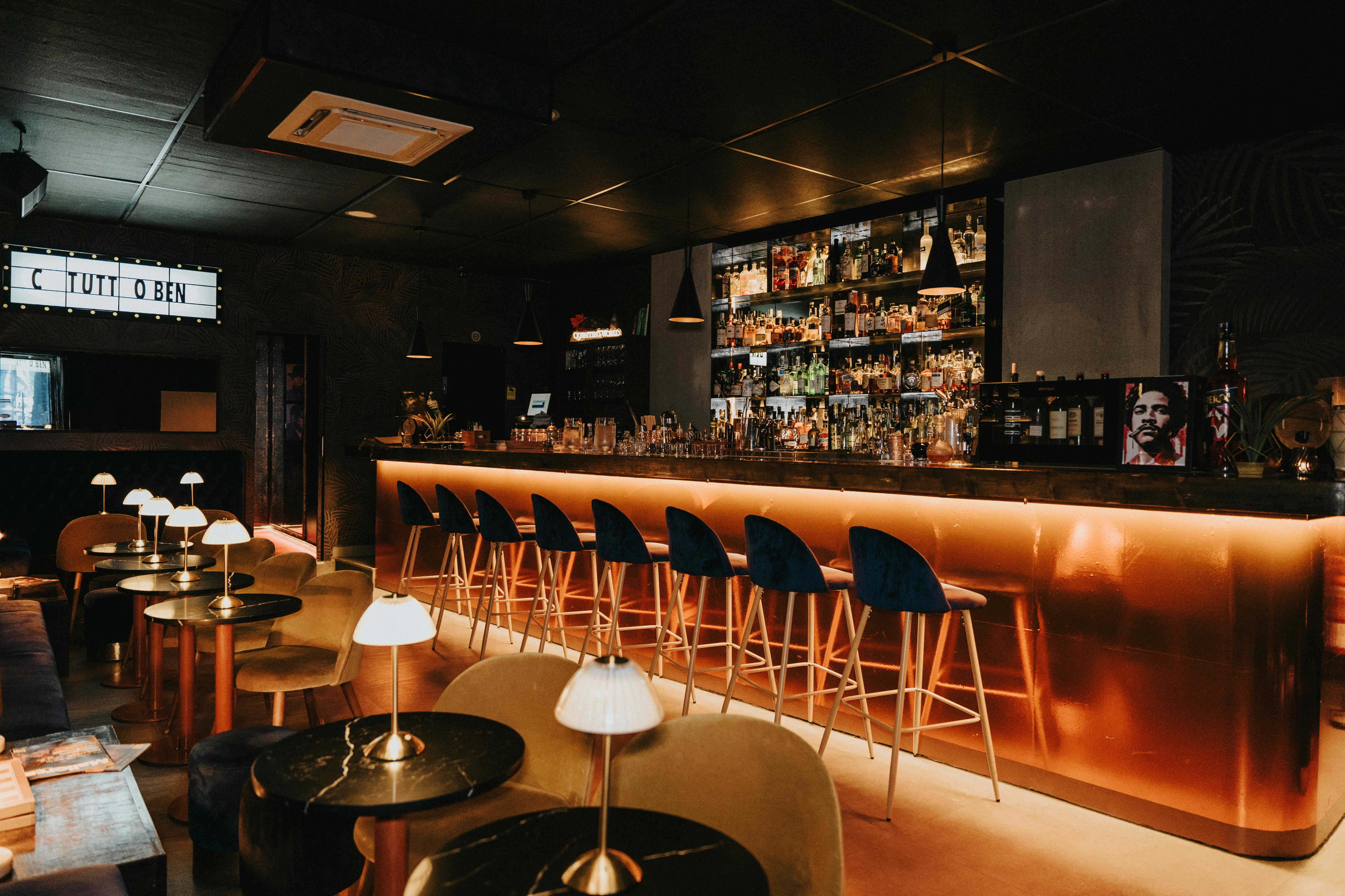 Free A warm and inviting bar interior with elegant seating and illuminated decor in Spain. Stock Photo