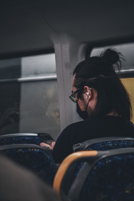 person wearing wireless earbuds commute