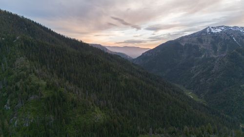 Free A serene dusk landscape in Irwin, Idaho showcasing lush green forests and distant mountains. Stock Photo