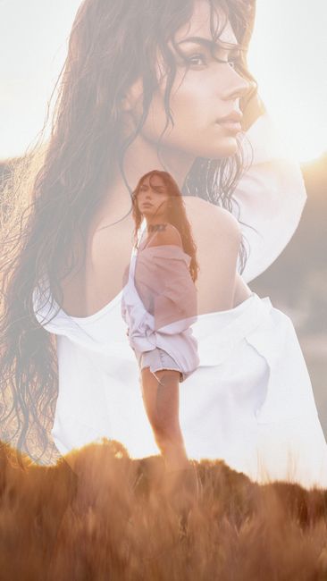 Artistic double exposure of a woman in a meadow with a dreamy sunlit atmosphere.