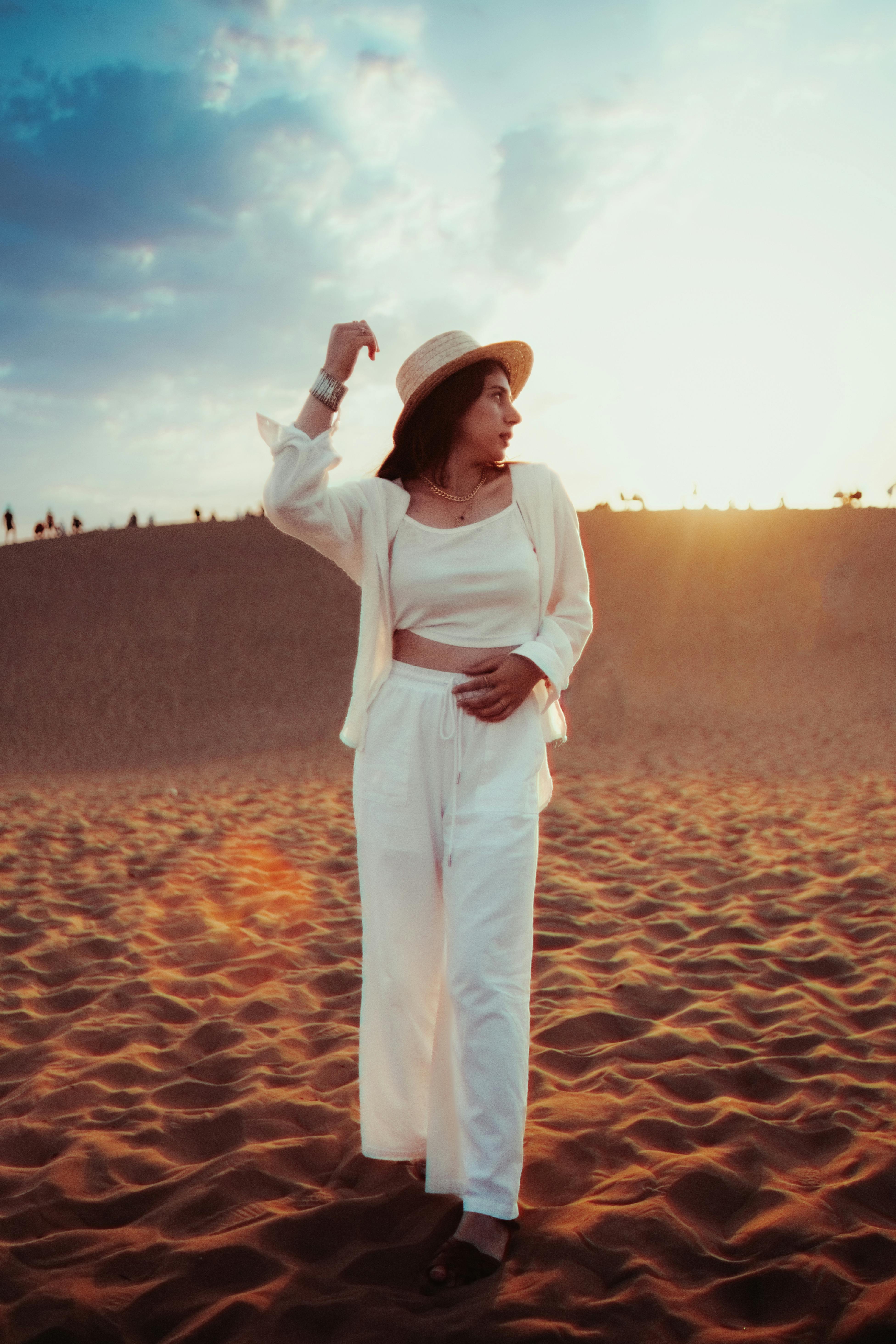 Free A woman in white standing on a sand dune Stock Photo